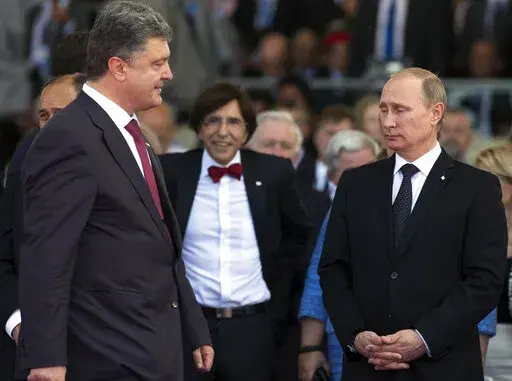 Ukrainian President Petro Poroshenko, left, walks past Russian President Vladimir Putin, right, during the commemoration of the 70th anniversary of the D-Day in Ouistreham, western France, June 6, 2014. The 2015 peace deal for eastern Ukraine was a diplomatic coup for Moscow, requiring Ukrainian authorities to offer self-rule to the Russia-backed separatist regions. (AP Photo/Alexander Zemlianichenko, file)