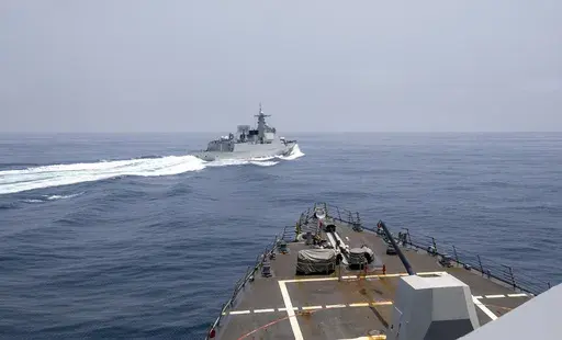 In this photo provided by the U.S. Navy, the USS Chung-Hoon observes a Chinese navy ship conduct what it called an "unsafe” Chinese maneuver in the Taiwan Strait, Saturday, June 3, 2023, in which the Chinese navy ship cut sharply across the path of the American destroyer, forcing the U.S. ship to slow to avoid a collision. The incident occurred as the American destroyer and Canadian frigate HMCS Montreal were conducting a so-called “freedom of navigation” transit of the strait between Taiw