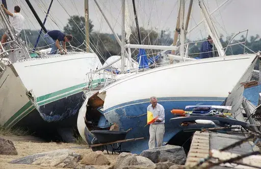 Boat owners gather their belongings along the shore in Dartmouth, Mass., Aug. 20, 1991, after Hurricane Bob swept through southern Massachusetts. New England is known for its fickle weather, powerful nor'easters and blizzards. Destructive hurricanes, however, are relatively rare and typically don't pack the same punch as tropical cyclones that hit the Southeast. Hurricanes usually lose some steam, becoming tropical storms, or extratropical storms, in northern waters. (AP Photo/Susan Walsh, File)