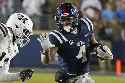 Mississippi running back Quinshon Judkins (4) looks to fend off Mississippi State safety Shawn Preston Jr. (12) during the second half of an NCAA college football game in Oxford, Miss., Thursday, Nov. 24, 2022. Judkins set the Rebels' single-season rushing record and led the SEC with 1,567 yards and 16 touchdowns as a freshman. (AP Photo/Rogelio V. Solis, File)