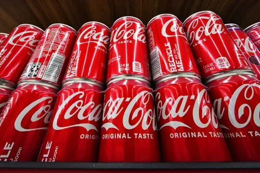 Cans of Coca-Cola are on display at a grocery market in Uniontown, Pa., April 24, 2022. The soft drink giant's sponsorship of the flagship U.N. climate conference, known as COP27, sparked an online backlash and highlighted broader concerns about corporate lobbying and influence. (AP Photo/Gene J. Puskar, File)
