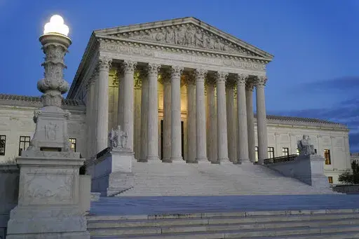 Light illuminates part of the Supreme Court building at dusk on Capitol Hill in Washington, Nov. 16, 2022. The court is set to hear arguments Wednesday in a case from North Carolina, where Republican efforts to draw congressional districts heavily in their favor were blocked by a Democratic majority on the state Supreme Court because the GOP map violated the state constitution. (AP Photo/Patrick Semansky, File)