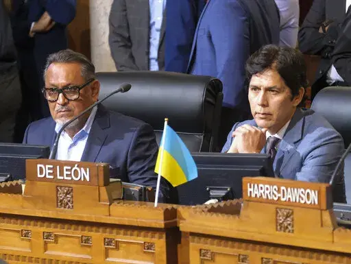 Los Angeles City Council members Gil Cedillo, left, and Kevin de Leon sit in chamber before starting the City Council meeting on Oct. 11, 2022, in Los Angeles. Two months after being entangled in a racism scandal that shook public trust in Los Angeles government, de Leon has has refused calls to resign and is attempting to rehabilitate his reputation. Cedillo, who vanished from public view shortly after the scandal emerged in October, has not attempted to return to City Hall meetings. (AP Photo/