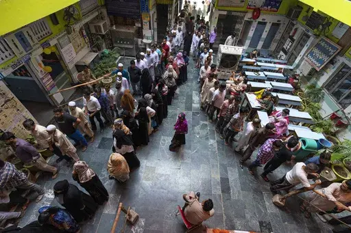 People queue up to cast their vote in the sixth round of polling in India's national election in New Delhi, India, Saturday, May 25, 2024. (AP Photo/Altaf Qadri)