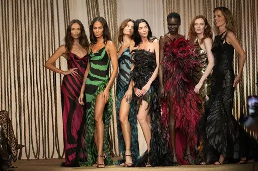 Models Joan Smalls, Isabeli Fontana, Natasha Poly, Maria Carla Boscono, Alex Wek, Karen Elson and Eva Herzigova wear a creations as part of the Roberto Cavalli Spring Summer 2025 collection, that was presented in Milan, Italy, Wednesday, Sept. 18, 2024. (AP Photo/Luca Bruno)