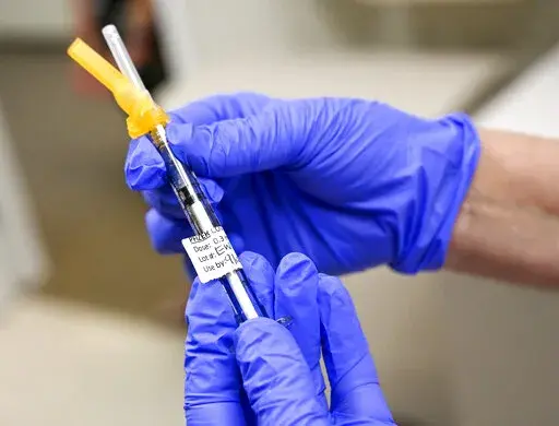 FILE - Nurse Mary Ezzat prepares to administer a Pfizer COVID-19 booster shot, Thursday, Aug. 19, 2021, at UCI Medical Center in Orange, Calif. (Jeff Gritchen/The Orange County Register via AP)