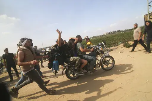 Palestinians transport a captured Israeli civilian, Noa Argamani, on a motorcycle from southern Israel, in the Gaza Strip on Oct. 7, 2023. Human Rights Watch released a report Wednesday, July 17, 2024, saying Hamas-led armed groups committed numerous war crimes during the Oct. 7 attack on southern Israel that precipitated the ongoing war in the Gaza Strip. (AP Photo, File)