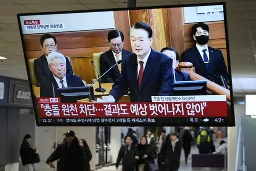 A TV screen shows footage of impeached South Korean President Yoon Suk Yeol's address at the final hearing of his trial during a news program at a bus terminal in Seoul, South Korea, Tuesday, Feb. 25, 2025. (AP Photo/Ahn Young-joo)