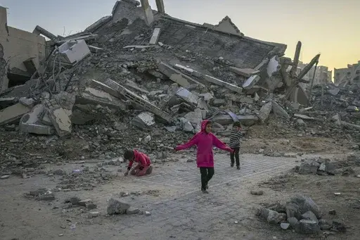 Palestinian children play next to a building destroyed by Israeli army strikes in the central Gaza Strip town of Khan Younis, Jan. 1, 2025. (AP Photo/Abdel Kareem Hana, File)