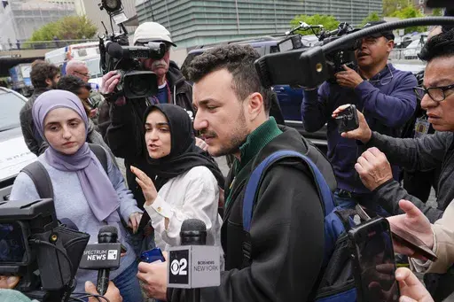 Members of the Columbia University Apartheid Divest group, including Sueda Polat, second from left, and Mahmoud Khalil, center, are surrounded by members of the media outside the Columbia University campus, Tuesday, April 30, 2024, in New York. (AP Photo/Mary Altaffer, File)