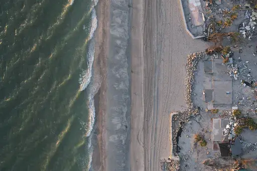 Waves roll in from the Gulf of Mexico toward lots where only empty foundations and debris remain after homes were swept away in Hurricane Milton, on Manasota Key in Englewood, Fla., Sunday, Oct. 13, 2024. (AP Photo/Rebecca Blackwell)