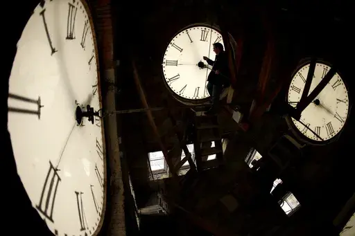 Custodian Ray Keen inspects a clock face before changing the time on the 100-year-old clock atop the Clay County Courthouse, March 8, 2014, in Clay Center, Kansas. (AP Photo/Charlie Riedel, File)