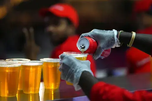 Staff member pours a beer at a fan zone ahead of the FIFA World Cup, in Doha, Qatar Saturday, Nov. 19, 2022. The last-minute decision to ban the sale of beer at World Cup stadiums in Qatar is the latest example of some the tensions that have played out ahead of the tournament. Qatari officials have for long said they were eager to welcome everybody but that visitors should also respect their culture and traditions. (AP Photo/Petr Josek)