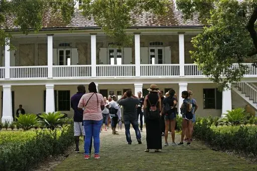 In this July 14, 2017 photo, visitors walk outside the main plantation house at the Whitney Plantation in Edgard, La. Descendants of slaves who lived and toiled in southeastern Louisiana won a key ruling Thursday, April 28, 2022 allowing their legal challenge to go forward against a $400 million grain elevator planned along the Mississippi River, although the company behind the project said it would likely appeal. The terminal would be located not far from the Whitney Plantation, which documents