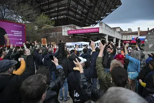 People take part in a protest organised by the Slovakian opposition parties in Bratislava, Wednesday, March. 27, 2024. People in Bratislava have formed a human chain around the building of Slovakia’s public radio and television to protest a plan by the government of populist Prime Minister Robert Fico to take over the broadcasters. The plan has been condemned President Zuzana Čaputová, opposition parties, local journalists, international media organizations, the European Commission and other