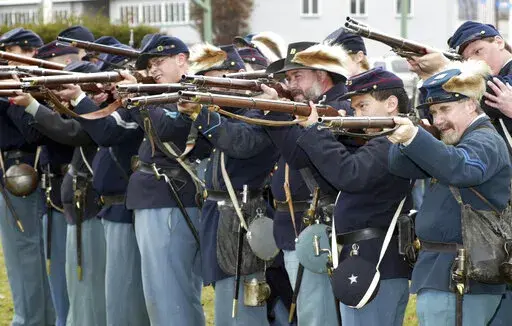 FILE — Members of the Mifflin Guard, consisting of re-enactors from New York, New Jersey and Pennsylvania, rehearse some battlefield tactics, on March 28, 2004, on the grounds of the Kingston Armory in Wilkes-Barre Pa. Some historical battle re-enactors in New York are holding their musket fire because of worries over the state's new gun law that declares parks, government property and a long list of other places off limits to guns beginning in Sept. 2022. (Dave Scherbenco/The Citizens' Voice 