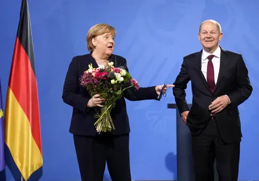 New elected German Chancellor Olaf Scholz, right, has given flowers to former Chancellor Angela Merkel during a handover ceremony in the chancellery in Berlin, Wednesday, Dec. 8, 2021. (Photo/Markus Schreiber)