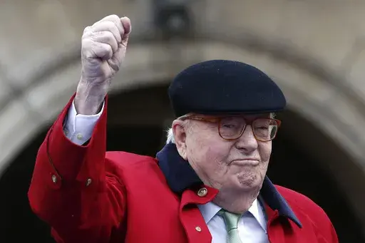 Former far-right National Front party leader Jean-Marie Le Pen clenches his fist at the statue of Joan of Arc, Monday May 1, 2017, in Paris. (AP Photo/Kamil Zihnioglu, File)