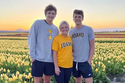 In this photo provided by Stacy Chapin, triplets Ethan, Maizie and Hunter Chapin pose in front of a tulip field in La Conner, Wash., in April of 2021. Ethan Chapin was one of four University of Idaho students found stabbed to death in a home near the Moscow, Idaho campus on Sunday, Nov. 13, 2022. Police are still searching for a suspect in the case. (Stacy Chapin via AP)