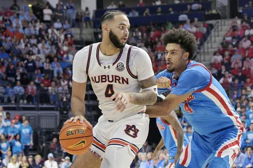 Auburn forward Johni Broome (4) is defended by Mississippi forward Jaemyn Brakefield (4) during the second half of an NCAA college basketball game in Oxford, Miss., Saturday, Feb. 1, 2025. (AP Photo/Bruce Newman)