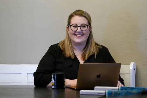 Nichol Khan checks new home listings from her rental home, Monday, April11, 2022, in Mesa, Ariz. America's housing market has grown increasingly frenzied and out-of-reach, especially for first-time buyers. (AP Photo/Matt York)
