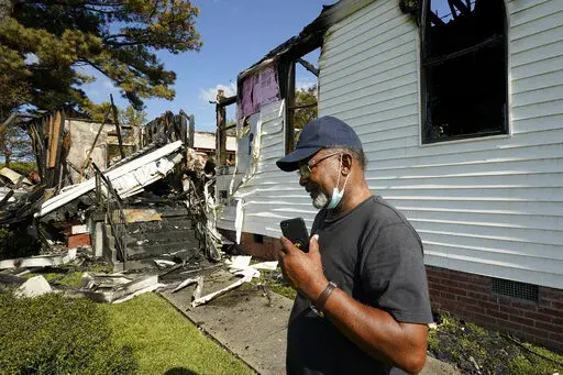 Elder Lloyd Caston, 73, walks around the remains Epiphany Lutheran Church near mid-town Jackson, Miss., Tuesday, Nov. 8, 2022. Authorities in Mississippi's capital city are on the hunt for a suspected arsonist who set several fires early Tuesday morning on and near the campus of Jackson State University, a historically Black public university. At least two of the buildings set ablaze were churches. (AP Photo/Rogelio V. Solis)
