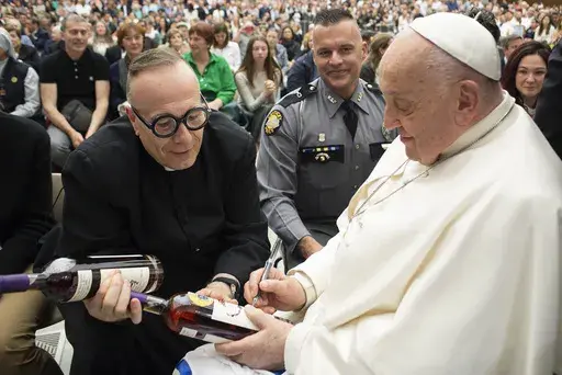 Pope Francis autographs a bottle of bourbon held by Kentucky Catholic priest Rev. Jim Sichko at the Vatican on May 1, 2024. (Courtesy Vatican Media via AP)