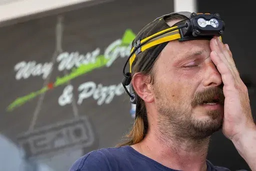 Way West Grill & Pizzeria owner Jake Vincent describes the amount of loss his restaurant and staff have suffered after being without power since Monday on Galveston Island on Saturday, July 13, 2024. Vincent estimates it will take three days reopen once power is restored, although he has no idea when that will happen. Vincent worries for his staff, most of whom are family members. (AP Photo/Annie Mulligan)