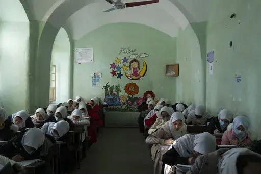 Afghan girls participate a lesson inside a classroom at Tajrobawai Girls High School, in Herat, Afghanistan, Nov. 25, 2021. Taliban hard-liners are turning back the clock in Afghanistan with a flurry of repressive edicts over the past days that hark back to their harsh rule from the late 1990s. Girls have been banned from going to school beyond the sixth grade, women are turned back from boarding planes if they travel unaccompanied by a male relative. (AP Photo/Petros Giannakouris, File)