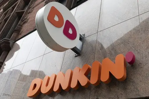 The Dunkin' logo is seen on a storefront, Friday, Oct. 14, 2022, in Boston. Reward programs have long been a way for brands to build loyalty and incentivize spending. But now some companies are becoming a bit more stingy, and customers are taking notice. Last fall, for example, many balked at Dunkin's decision to stop offering a free drink on their birthday and instead give them triple loyalty points on their purchase. (AP Photo/Michael Dwyer, File)