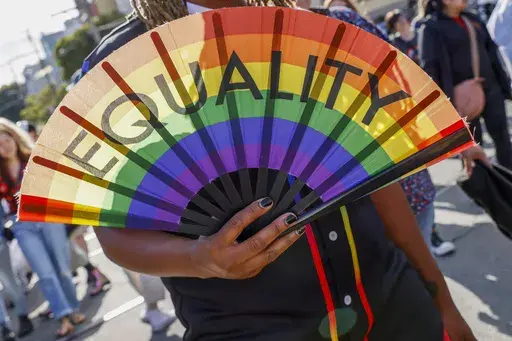 A person holds a fan that reads "Equality" during the 31st annual San Francisco Dyke March on Saturday, June 24, 2023. (Santiago Mejia/San Francisco Chronicle via AP)