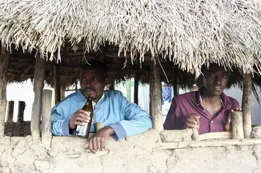 Benson Muhereza enjoys tonto at a local bar in Majengo village, Mbarara, Uganda, Dec. 10, 2023. Tonto is a legendary traditional drink in Uganda. But the fermented banana juice is under threat as authorities move to regulate the production of what are considered illicit home brews. (AP Photo/Hajarah Nalwadda)