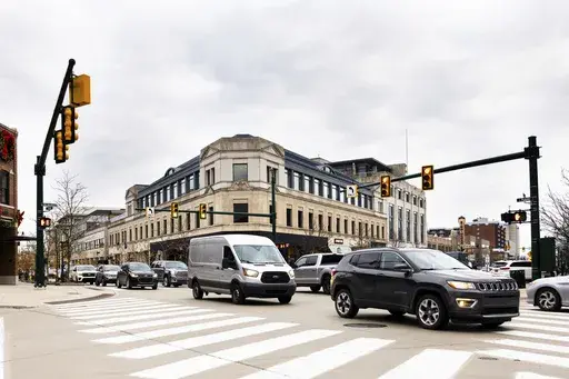 This undated photo provided by the University of Michigan College of Engineering shows vehicles as they drive through the Old Woodward Avenue and East Maple signalized intersection, which was retimed using the Optimized Signal as a Service (OSaaS), in Birmingham, Mich. Smarter vehicles could mean some of the most dramatic changes for the traditional traffic signal since the yellow light was added more than a century ago. (Jeremy Little/University of Michigan College of Engineering via AP)