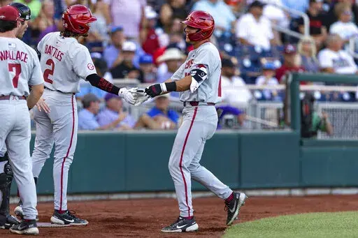 Arkansas' Chris Lanzilli (18) gets five from Jalen Battles (2) after his home run in the second inning against Mississippi during an NCAA College World Series baseball game Wednesday, June 22, 2022, in Omaha, Neb. (AP Photo/John Peterson)