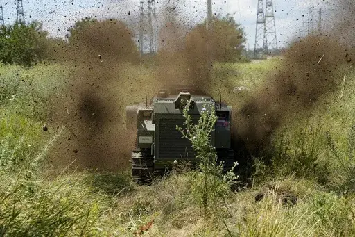 A Russian military robotic vehicle detonates a land mine on a mine clearing mission to defuse mines along the high voltage line in Mariupol, on the territory which is under the Government of the Donetsk People's Republic control, eastern Ukraine, July 13, 2022. This photo was taken during a trip organized by the Russian Ministry of Defense. (AP Photo, File)