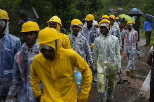 Rescuers walk towards the site of a landslide in Raigad district, western Maharashtra state, India, Thursday, July 20, 2023. While some people are reported dead many others feared trapped under piles of debris. (AP Photo/Rafiq Maqbool)