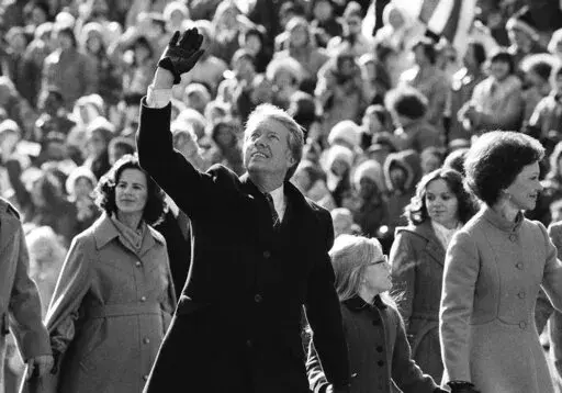 U.S. President Jimmy Carter waves to the crowd while walking with his wife, Rosalynn, and their daughter, Amy, along Pennsylvania Avenue. The Carters elected to walk the parade route from the Capitol to the White House following his inauguration in Washington, Jan. 20, 1977. Carter announced his campaign for the presidency in December 1974. At that point he had never met an American president. He later said part of what nudged him into the race was meeting several candidates ahead of the 1972 ca