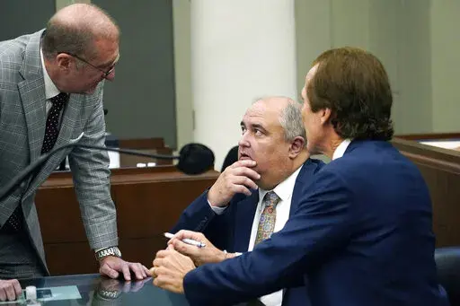 John Davis, former director of the Mississippi Department of Human Services, confers with defense attorneys Merrida Coxwell, right, and Charles Mullins, left, in Jackson, Miss., on Sept. 22, 2022. Davis pleaded guilty to state and federal charges in a conspiracy to misspend tens of millions of dollars that were intended to help needy families in one of the poorest states in the U.S. as part of the largest public corruption case in Mississippi history. (AP Photo/Rogelio V. Solis, File)