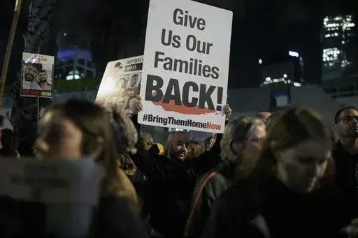 A man holds a sign calling for the release of the hostages taken by Hamas militants into the Gaza Strip during a demonstration at the Hostages Square in Tel Aviv, Israel, Saturday Jan. 13, 2024. Sunday marks 100 days that Israel and Hamas have been at war after Hamas' cross-border attack on Oct. 7 in which the group killed some 1,200 people, mostly civilians, and took 250 others hostage. In the Gaza Strip, health authorities say the death toll already has eclipsed 23,000 people.(AP Photo/Leo Cor