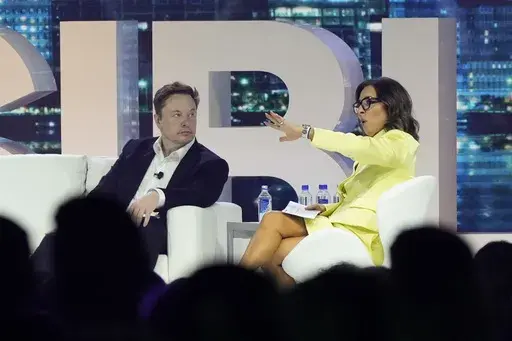 Twitter CEO Elon Musk, center, speaks with Linda Yaccarino, chairman of global advertising and partnerships for NBC, at the POSSIBLE marketing conference, Tuesday, April 18, 2023, in Miami Beach, Fla. Musk announced Friday, May 12, 2023, that he's hiring Yaccarino to be the new CEO of San Francisco-based Twitter, which is now called X Corp. (AP Photo/Rebecca Blackwell, File)