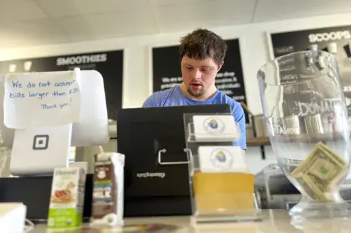 Patrick Chapman, 27, prepares for customers Thursday, March 2, 2023, at The Golden Scoop, an Overland Park, Kan., ice cream and coffee shop that employs workers with developmental disabilities, paying them more than minimum wage. But some disabled workers employed at so-called sheltered workshops are earning far less than minimum wage, an issue that has captured the attention of lawmakers in the state. Disability rights advocates say the practice is discriminatory and more than a dozen states ha