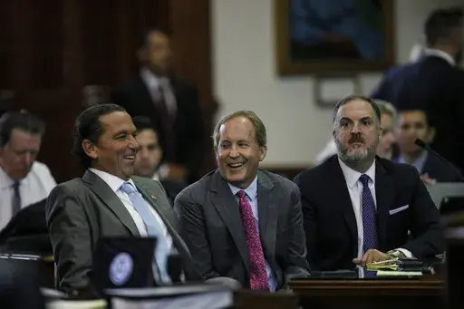 Texas Attorney General Ken Paxton, center, sits between defense attorneys Tony Buzbee, left, and Mitch Little, right, before his impeachment trial resumes in the Senate Chamber at the Texas Capitol on Friday, Sept. 15, 2023, in Austin, Texas. (Sam Owens/The San Antonio Express-News via AP, Pool)