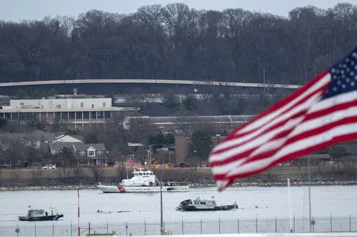 Police and coast guard boats are seen around a wreckage site in the Potomac River from Ronald Reagan Washington National Airport, Thursday, Jan. 30, 2025, in Arlington, Va. (AP Photo/Jose Luis Magana)