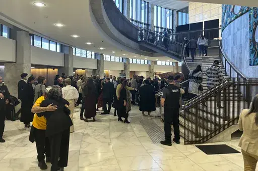 People arrive at Parliament in Wellington, New Zealand, on Wednesday, July 24, 2024, for the tabling of a wide-ranging independent inquiry into the abuse of children and vulnerable adults in care over the span of five decades wrote in a blistering final report. (AP Photo/Charlotte Graham-McLay)
