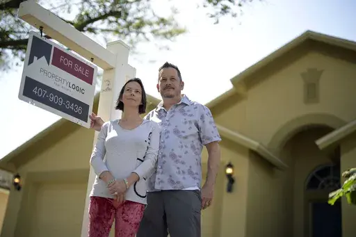 Scott and Sheila Collett stand in front of the home that they recently purchased, Tuesday, Feb. 21, 2023, in Valrico, Fla. Collett negotiated a seller-paid mortgage rate buydown to close the deal on the four-bedroom, two-bathroom house with a pool. (AP Photo/Phelan M. Ebenhack)
