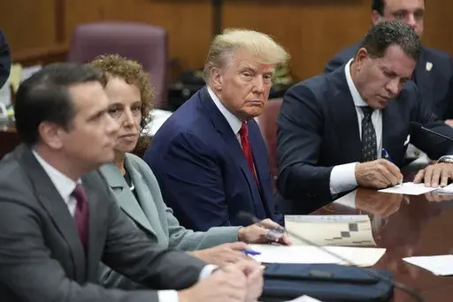 Former President Donald Trump sits at the defense table with his legal team in a Manhattan court, April 4, 2023, in New York. Ten months before Trump is scheduled to stand trial in his historic New York City criminal case, Manhattan prosecutors are in a tug of war with the former president's legal team over precisely where he will be tried. Trump’s lawyers are angling to have the hush-money case moved to federal court while the Manhattan district attorney’s office, in court papers Tuesday, M