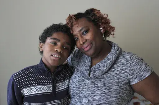 DarNisha Hardaway poses with her son Joseph, 12, at home in Detroit, Monday, Feb. 17, 2025. (AP Photo/Paul Sancya)