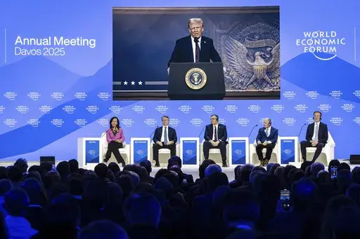 US President Donald J. Trump is shown on screens as he addresses via remote connection a plenary session in the Congress Hall, during the 55th annual meeting of the World Economic Forum (WEF), in Davos, Switzerland, Thursday, Jan. 23, 2025. (Michael Buholzer/Keystone via AP)