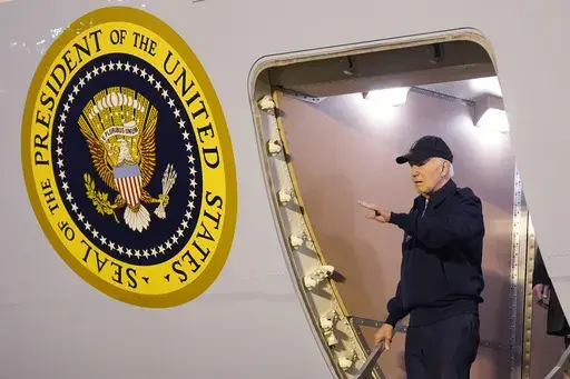 President Joe Biden waves as he walks down the steps of Air Force One at Dover Air Force Base in Delaware, Wednesday, July 17, 2024. Biden is returning to his home in Rehoboth Beach, Del., to self-isolate after testing positive for COVID-19. (AP Photo/Susan Walsh)