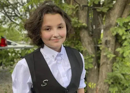In this image provided Malia Pila, Nex Benedict poses outside the family's home in Owasso, Okla., in December 2023. The death of Nex Benedict, a nonbinary student the day after a fight inside an Oklahoma high school restroom, has been ruled a suicide, the state medical examiner's office said Wednesday, March 13, 2024. (Sue Benedict via AP, File)